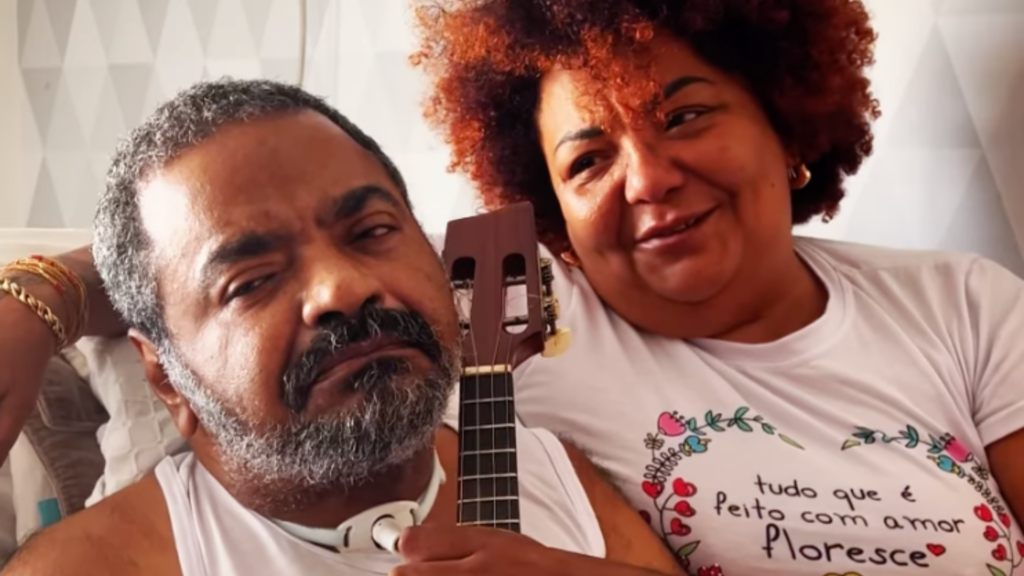 Babi Cruz, mulher de Arlindo Cruz, emociona ao mostrar cantor com banjo 1 Arlindo Cruz segurando banjo com ajuda da sua mulher, Babi Cruz