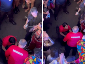 A MC Pepita (no canto direito) com o microfone em mãos, pedindo a presença dos bombeiros